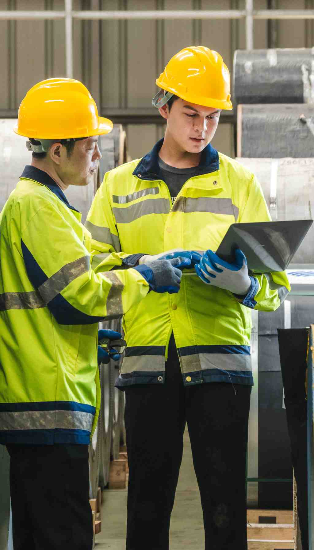 Engineer wearing a hard hat and high-visibility vest using a tablet to inspect electrical systems, representing compliance and safety checks ahead of HSA inspections in 2025.