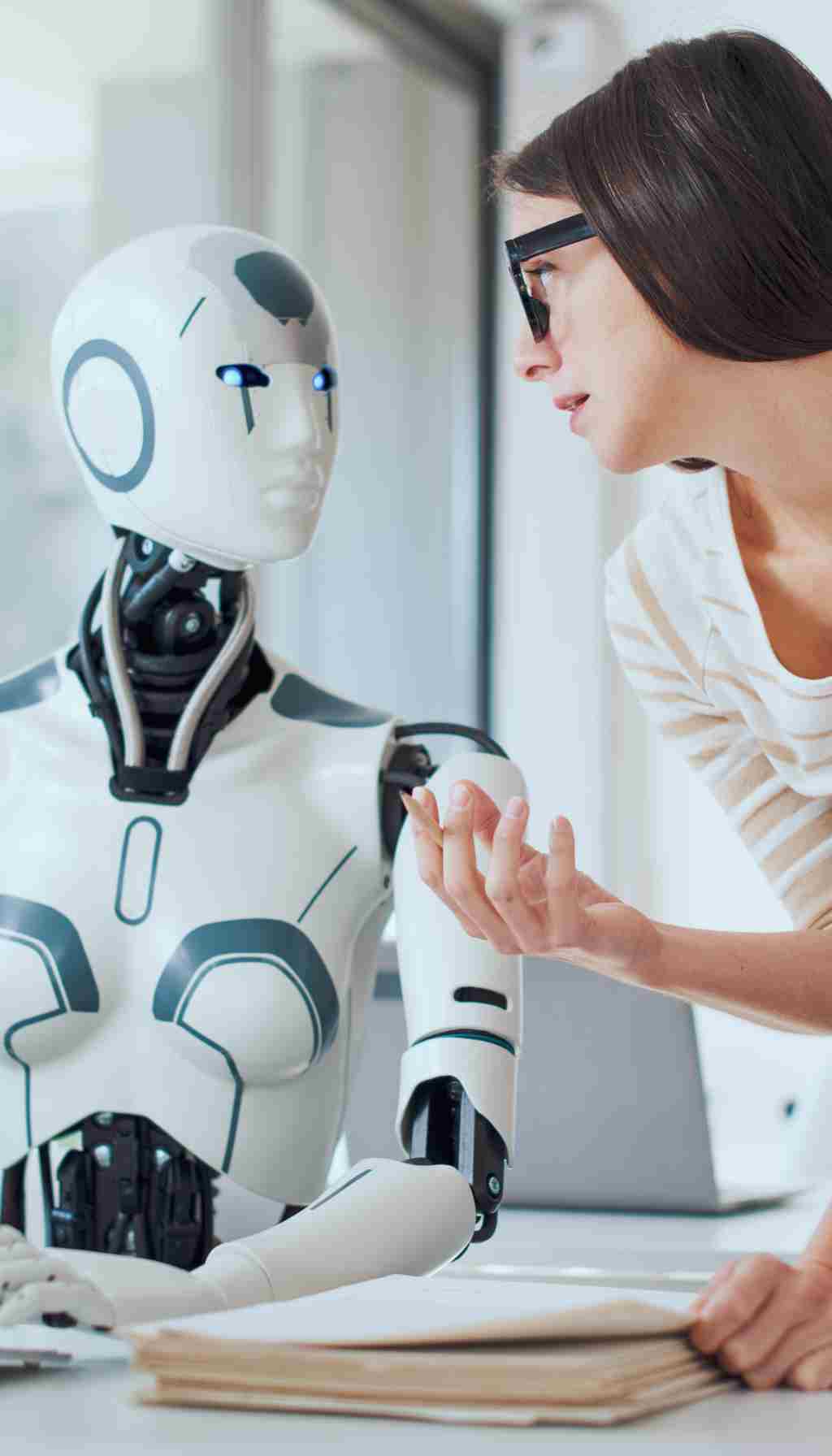 Human–Robot Interaction in Modern Workplace Safety Woman interacting with a humanoid robot in an office setting, illustrating human–AI collaboration for workplace safety.
