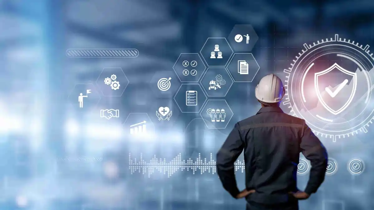 Engineer wearing a safety helmet viewing a futuristic digital interface with safety and compliance icons, symbolising AI-driven safety management and workplace compliance in 2025.