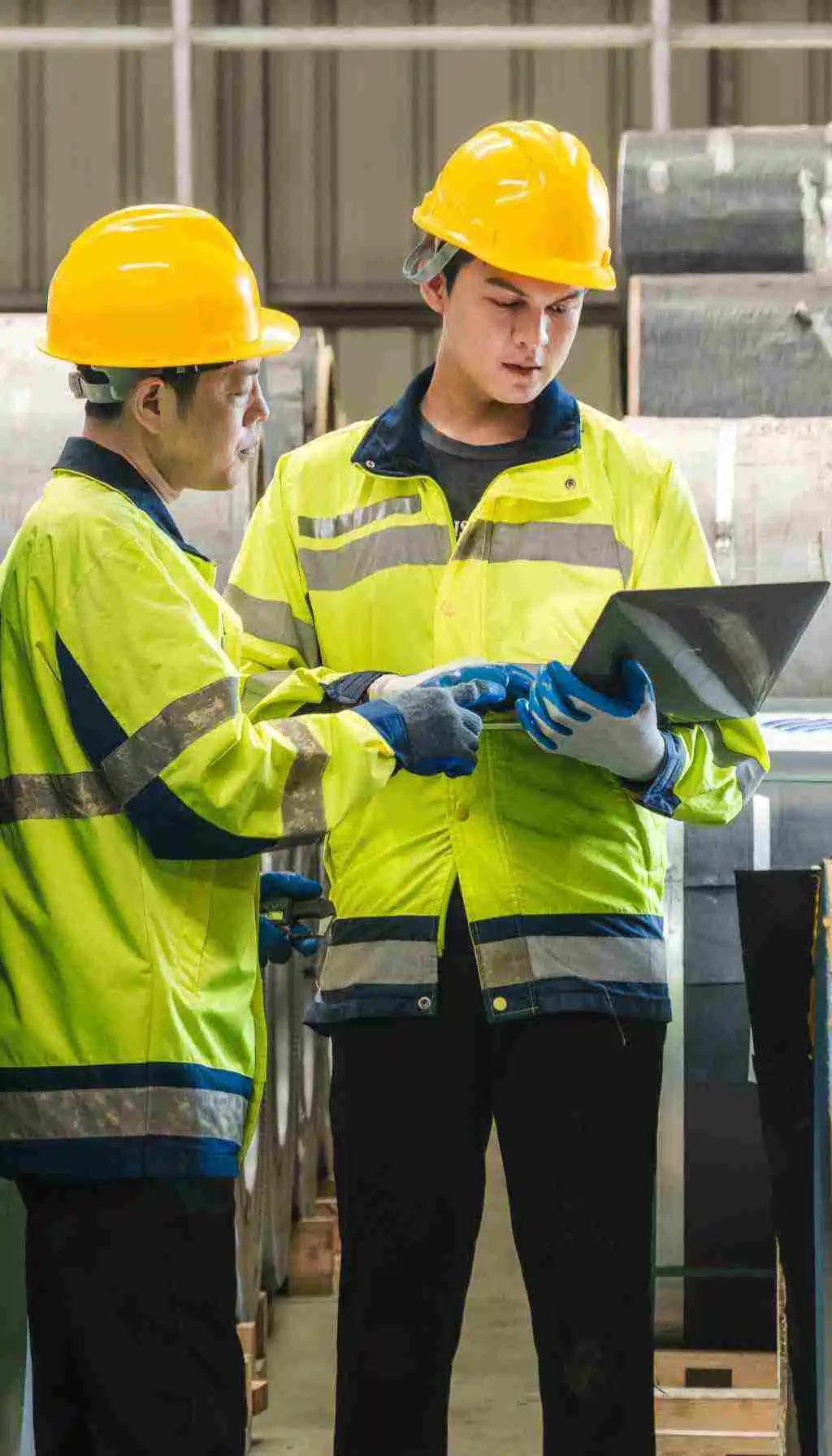 Engineer wearing a hard hat and high-visibility vest using a tablet to inspect electrical systems, representing compliance and safety checks ahead of HSA inspections in 2025.