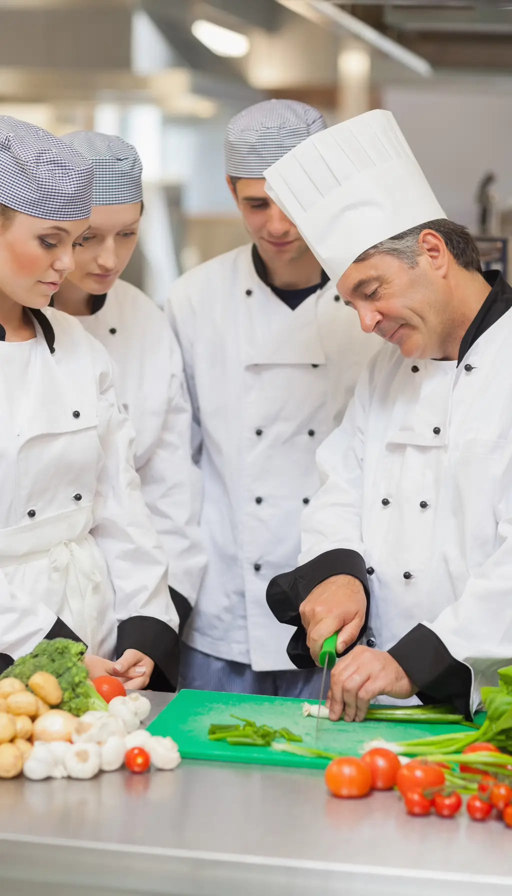 Head chef supervising kitchen staff during food preparation, demonstrating management-level food safety training under HACCP Level 3