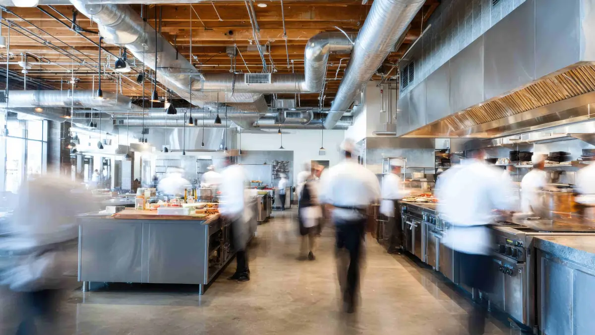 Woman completing an online food safety and HACCP training course on a laptop at a kitchen table