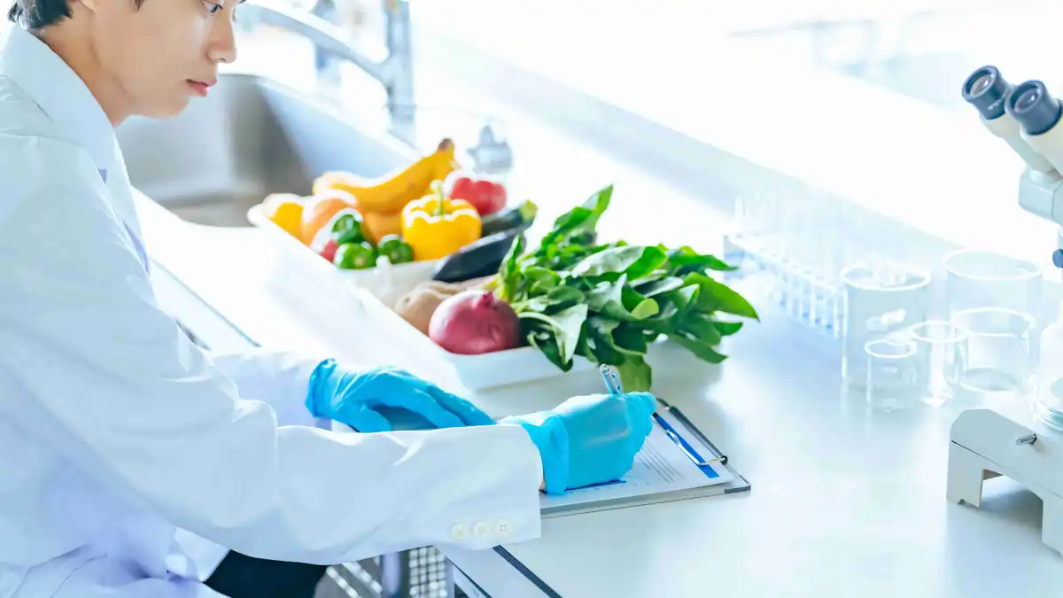 Woman completing an online food safety and HACCP training course on a laptop at a kitchen table