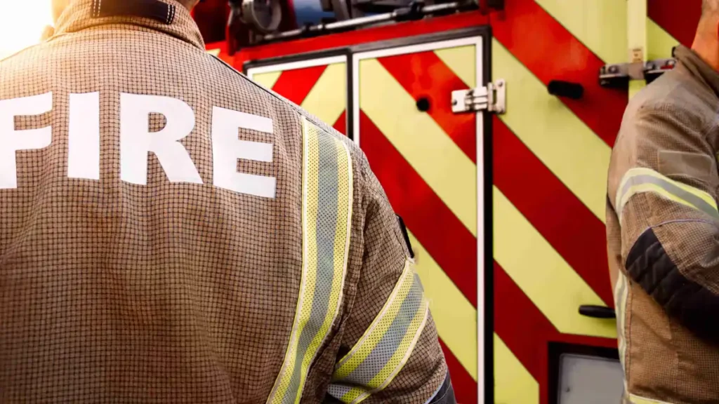 Fire service personnel standing beside fire engine during emergency response in Ireland