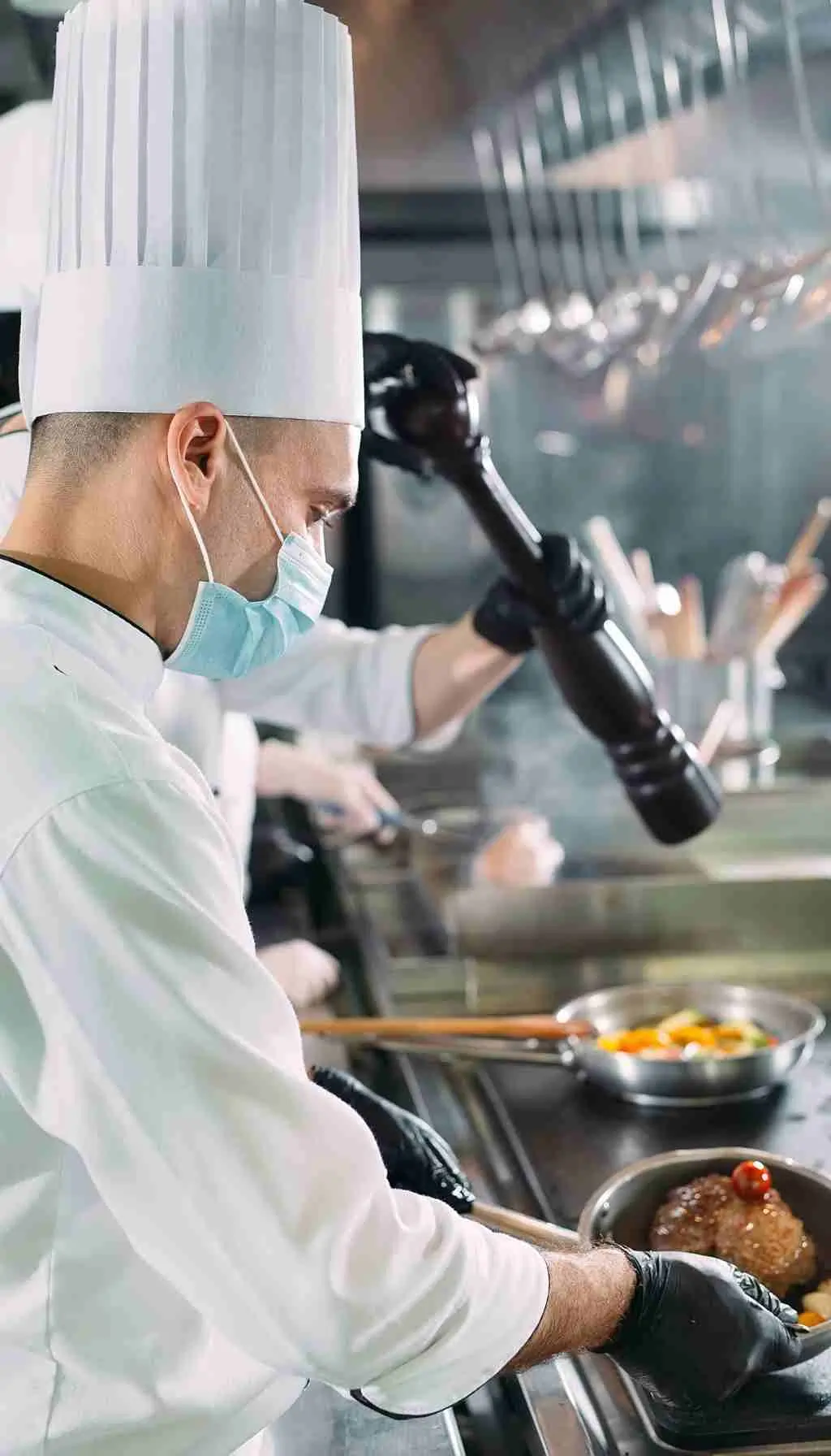 Food handlers preparing ready-to-eat salad in a commercial kitchen following HACCP hygiene controls