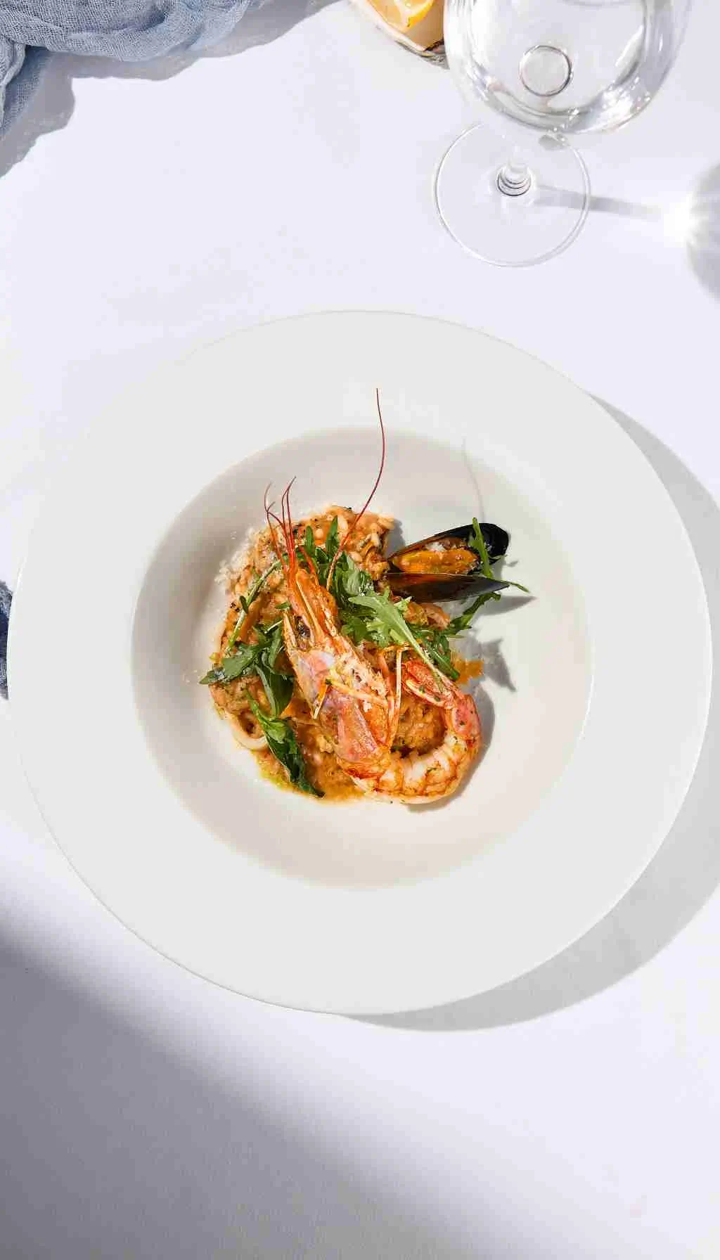 Healthcare catering staff plating meals while a supervisor checks standards using a clipboard